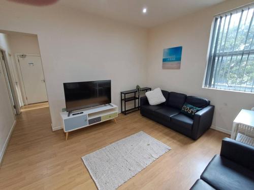 リバプールにあるByrom House Apartmentsのソファと薄型テレビのあるリビングルーム