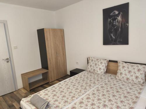 a bedroom with a bed and a wooden cabinet at Къща за гости Алтея in Sarovtsi
