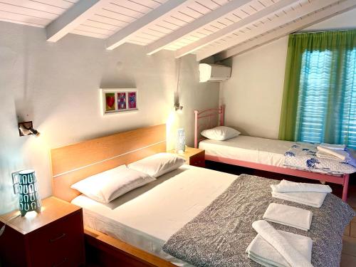 Un dormitorio con dos camas y una ventana. en Villa Konari, en Tolo