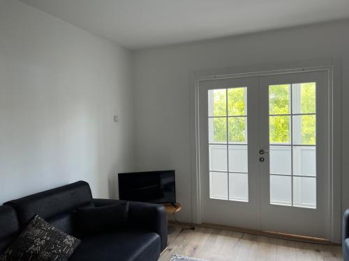 sala de estar con sofá y puerta corredera en Apartman Boža 2, en Kuršumlija