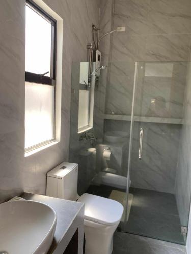 a bathroom with a toilet and a glass shower at Villa Bella in Puerto Princesa City