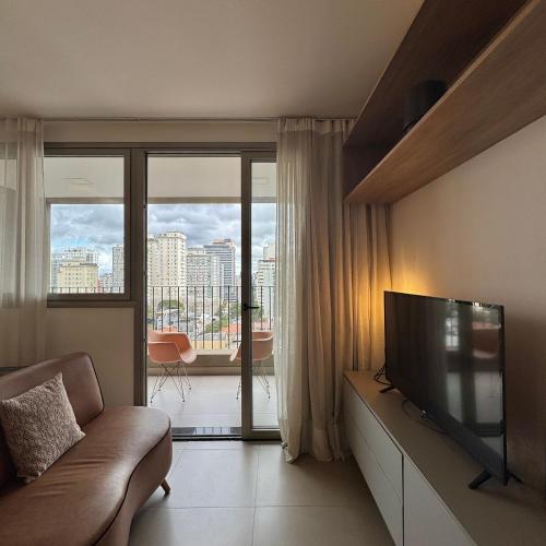 a living room with a couch and a flat screen tv at Apartamentos Prime - Jardins in Sao Paulo