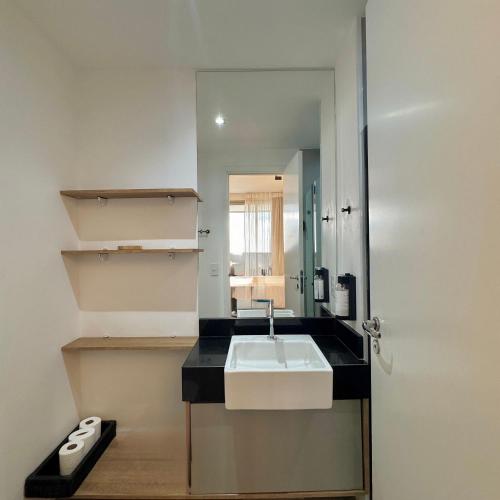 a bathroom with a sink and a mirror at Apartamentos Prime - Jardins in Sao Paulo