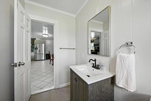 a white bathroom with a sink and a mirror at Liberty Lakefront Home - Pool, Hot Tub, Sauna in Ferndale
