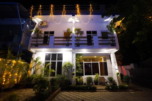 a white house with a balcony at night at Airport 4 Season Transit Hotel in Katunayake