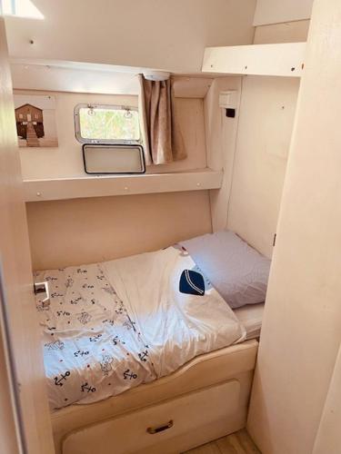 a small bedroom with a bed in a small room at Bateau Péniche à quai 6 couchages in Colombiers