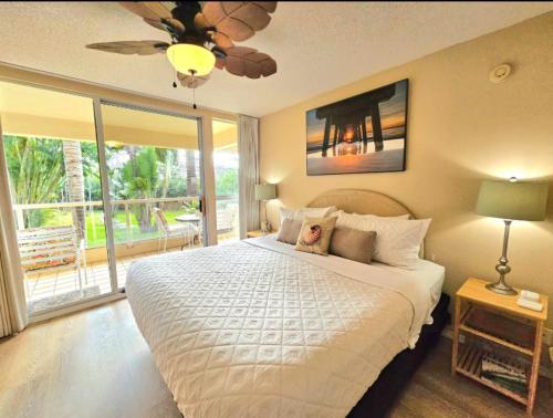 ein Schlafzimmer mit einem großen Bett und einem Deckenventilator in der Unterkunft Tropical Family Resort Near Beach-Full Kitchen, AC & WIFI in Wailea