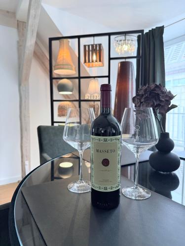 a bottle of wine sitting on a table with two wine glasses at designAparts - I - Penthouse mit Dachterrasse in Bayreuth