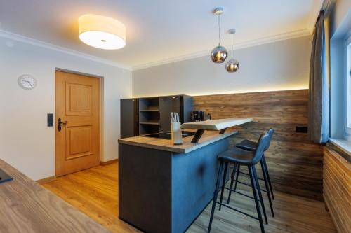 a kitchen with a counter and a bar with stools at Ahorn Chalet in Mayrhofen