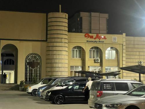 a row of parked cars in front of a building at Osh Art Hotel in Osh