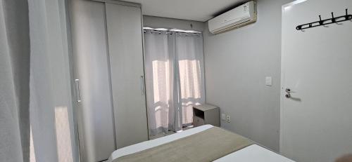 a white room with a mirror and a bed at 2201 - Vista mar lateral! Apto para 5 pessoas com ar e vaga in Fortaleza