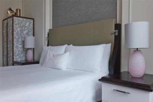 a bedroom with a large bed with white pillows at Waldorf Astoria Amsterdam in Amsterdam