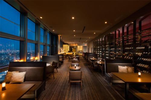 a restaurant with tables and chairs and a view of a city at Hilton Fukuoka Sea Hawk in Fukuoka