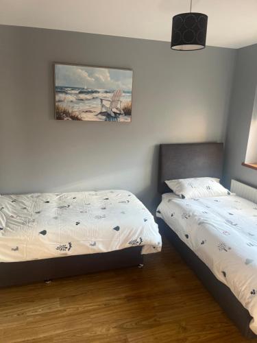 a bedroom with two beds and a picture on the wall at Beachside - Stunning sea view townhouse across the road from the beach in Kilkeel