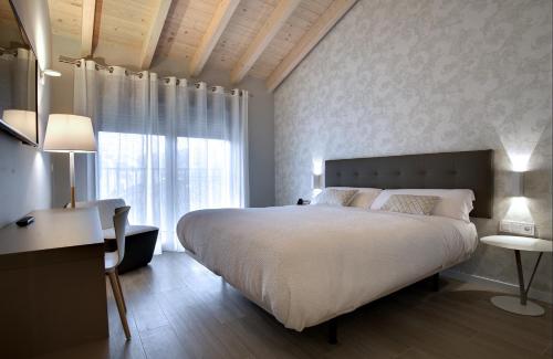 a bedroom with a large bed and a large window at Hotel Lemik in Alsasua