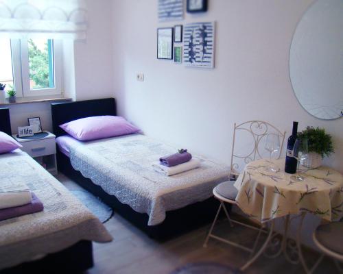 1 dormitorio con 2 camas, mesa y espejo en Hoc Loco Split en Split