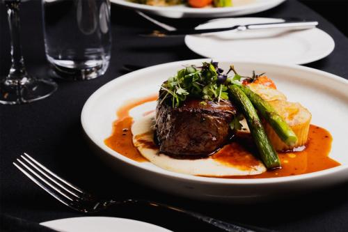 a plate of food with meat and vegetables on a table at Parmelia Hilton Perth in Perth
