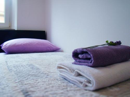 1 cama con toalla morada y almohada en Hoc Loco Split en Split