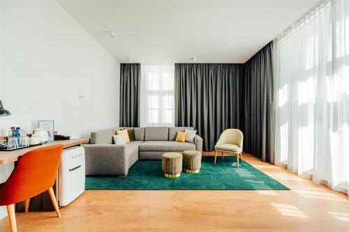a living room with a couch and a table at Hilton Garden Inn Radom in Radom