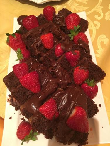 a piece of chocolate cake with strawberries on a plate at Hotel Karagianni in Volos