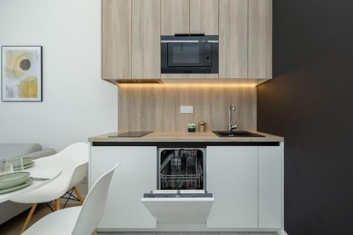 a small kitchen with a sink and a microwave at Shelter Apartments by Solarento in Rogowo
