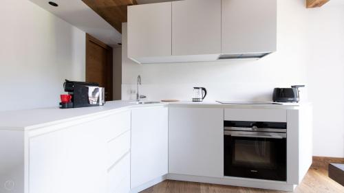 a kitchen with white cabinets and a black oven at Morcelli 4 - Bajona in Bormio