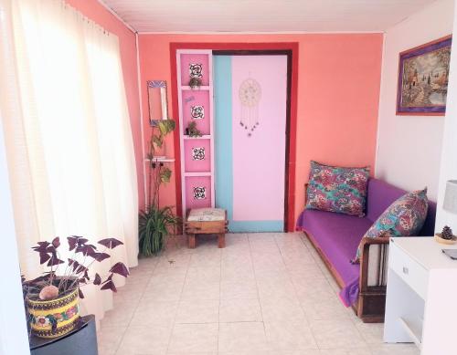 a room with a purple couch and a pink door at La Celeste casa de playa in Las Grutas