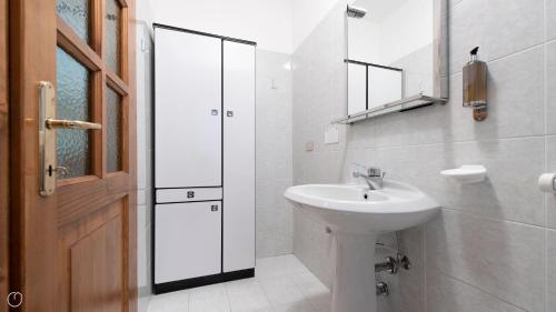 a white bathroom with a sink and a mirror at Monte Solena 45C in Bormio
