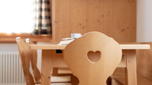 a wooden table with a heart shaped chair at Italianway - Adda 10 in Valdidentro