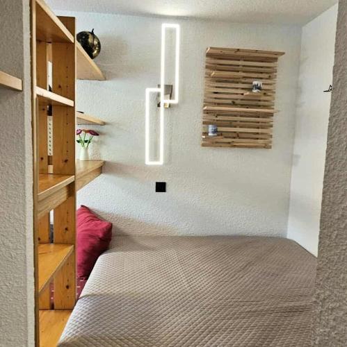 une pièce avec un couloir avec des étagères et un escalier dans l'établissement Résidence Aigue-marine - Studio pour 4 Personnes 41, à Mâcot La Plagne