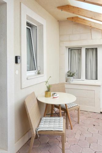 a patio with a table and chairs and windows at Apartments Coco in Hvar
