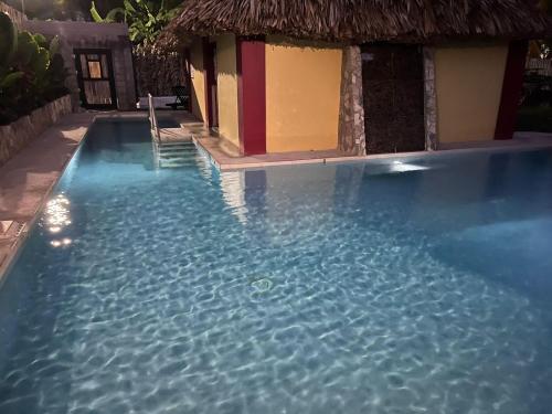 a swimming pool with a house and some water at Lamanai Hotel & Marina in Orange Walk