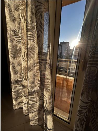 una tenda su una finestra con vista su un balcone di Vlora Apartaments a Vlorë