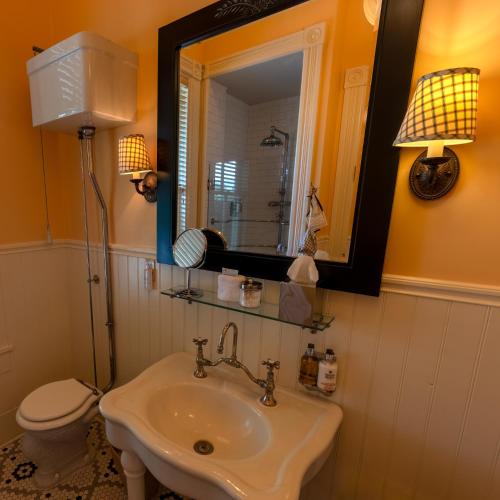 a bathroom with a sink and a toilet and a mirror at Tallman Hotel in Upper Lake
