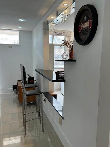 an office with a counter and a desk and a clock at Residencial Ilha do Governador in Rio de Janeiro