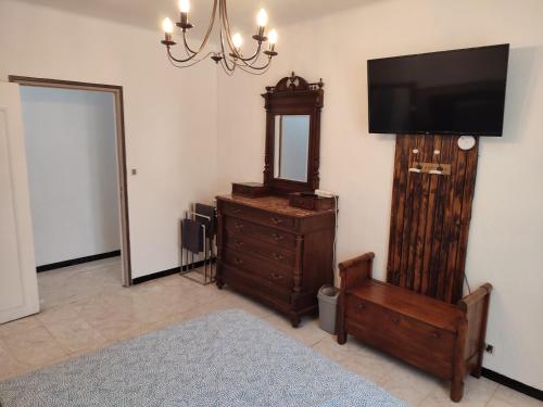 a room with a television and a dresser with a mirror at La pergola in Valros