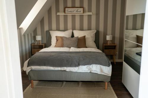a bedroom with a bed with a striped wall at Ferienwohnung Am Hafen in Bleckede
