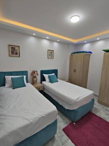 two beds in a room with twoermottermott at Oasis marina الاحياء in Hurghada