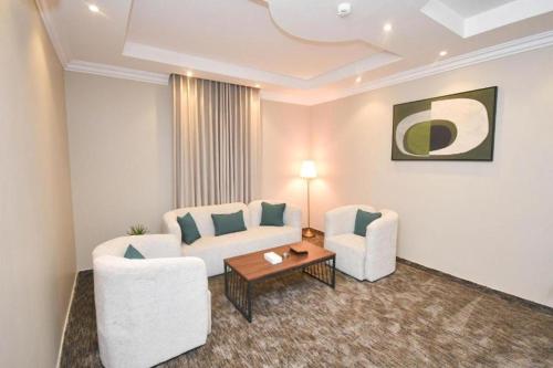 a living room with a couch and two chairs and a table at شقق برج الفخامة in Quai