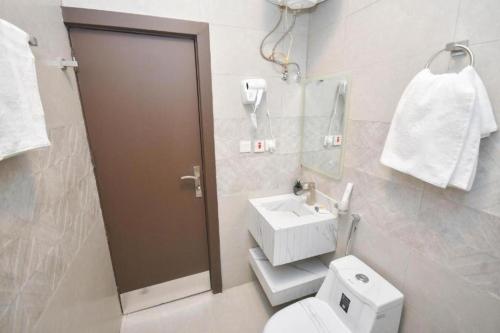 a bathroom with a toilet and a sink at شقق برج الفخامة in Quai