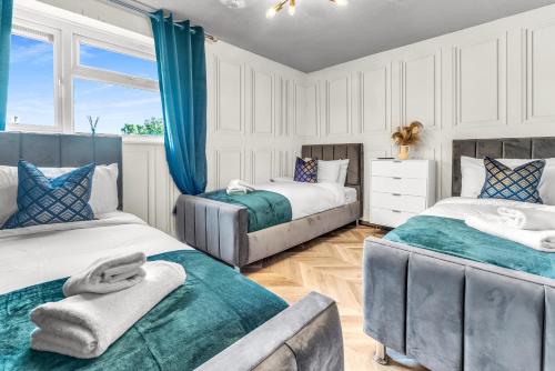 - 2 lits dans une chambre dotée de rideaux bleus dans l'établissement Large 4 Bedroom House - Sleeps 10 - Birmingham City Centre - Perfect for Work, Families, Groups, Business Travellers & Contractors - FREE PARKING - By 02 Academy, Bullring, Newstreet, Selfridges - SMART TVs in all rooms, à Birmingham
