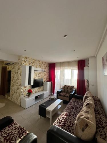 a living room with a couch and a table at Confort Studio in Popeşti-Leordeni