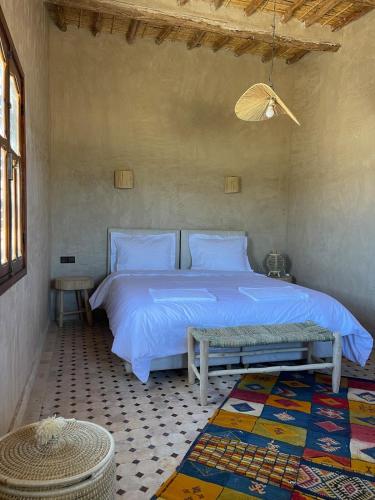 a bedroom with a bed with a blue comforter at Skoura Ranch Palm Grove in Ouarzazate