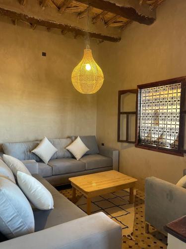 a living room with a couch and a table at Skoura Ranch Palm Grove in Ouarzazate