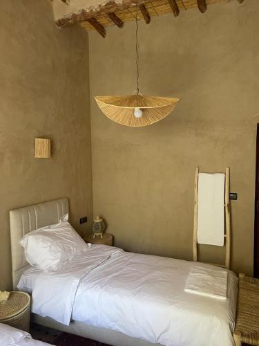 a bedroom with a bed and a hanging light at Skoura Ranch Palm Grove in Ouarzazate