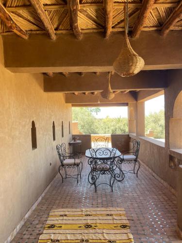 a patio with a table and chairs on a patio at Skoura Ranch Palm Grove in Ouarzazate
