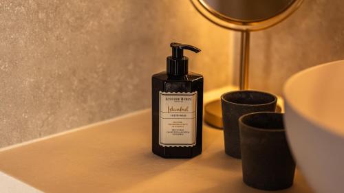 a bottle of hand soap sitting on a bathroom counter at Gezellig vakantiehuis voor 12 personen in Boutersem