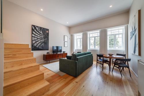 a living room with a green couch and a table at Art Living Estação by Home Sweet Home Aveiro in Aveiro