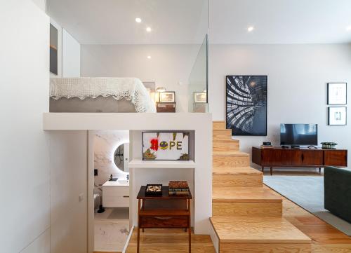 a living room with a staircase leading to a bedroom at Art Living Estação by Home Sweet Home Aveiro in Aveiro