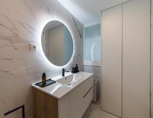 a white bathroom with a sink and a mirror at Art Living Estação by Home Sweet Home Aveiro in Aveiro